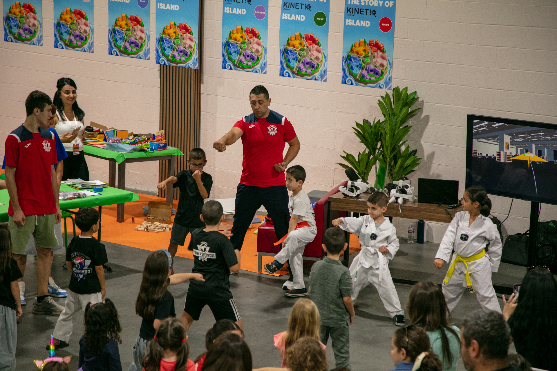 Children practicing martial arts with an instructor at a KinetIQ event